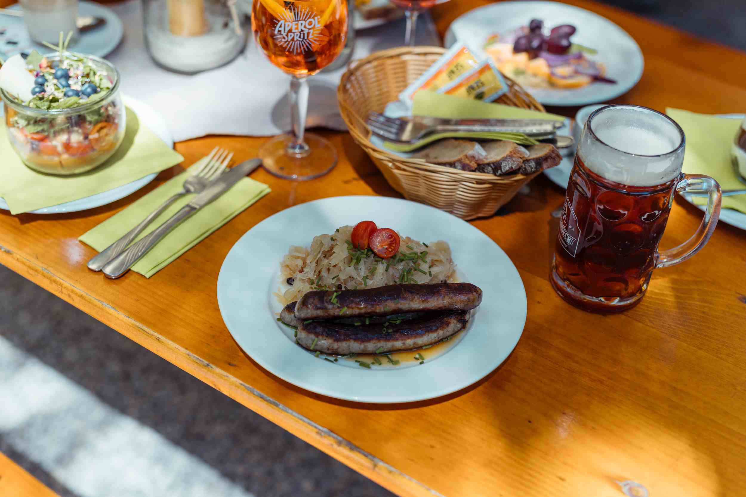 Gedeckte Tische zwischen Wildblumen im Biergarten